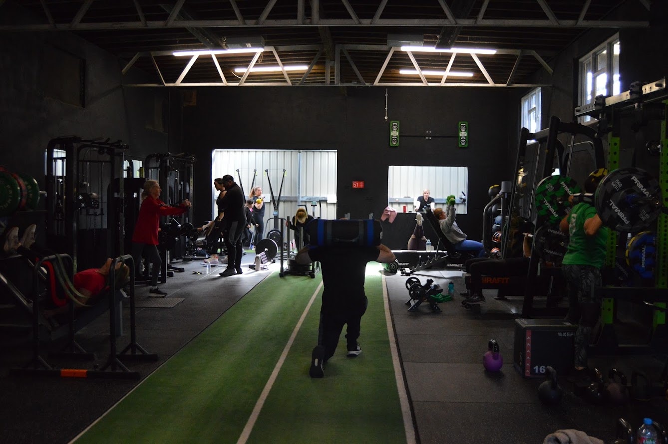 Personal trainer coaching client in private gym